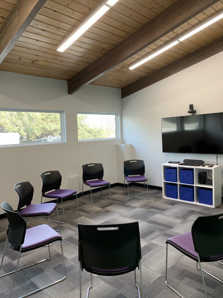 Seven chairs in a half circle around a tv group room at Norhtpoint Imagine boise