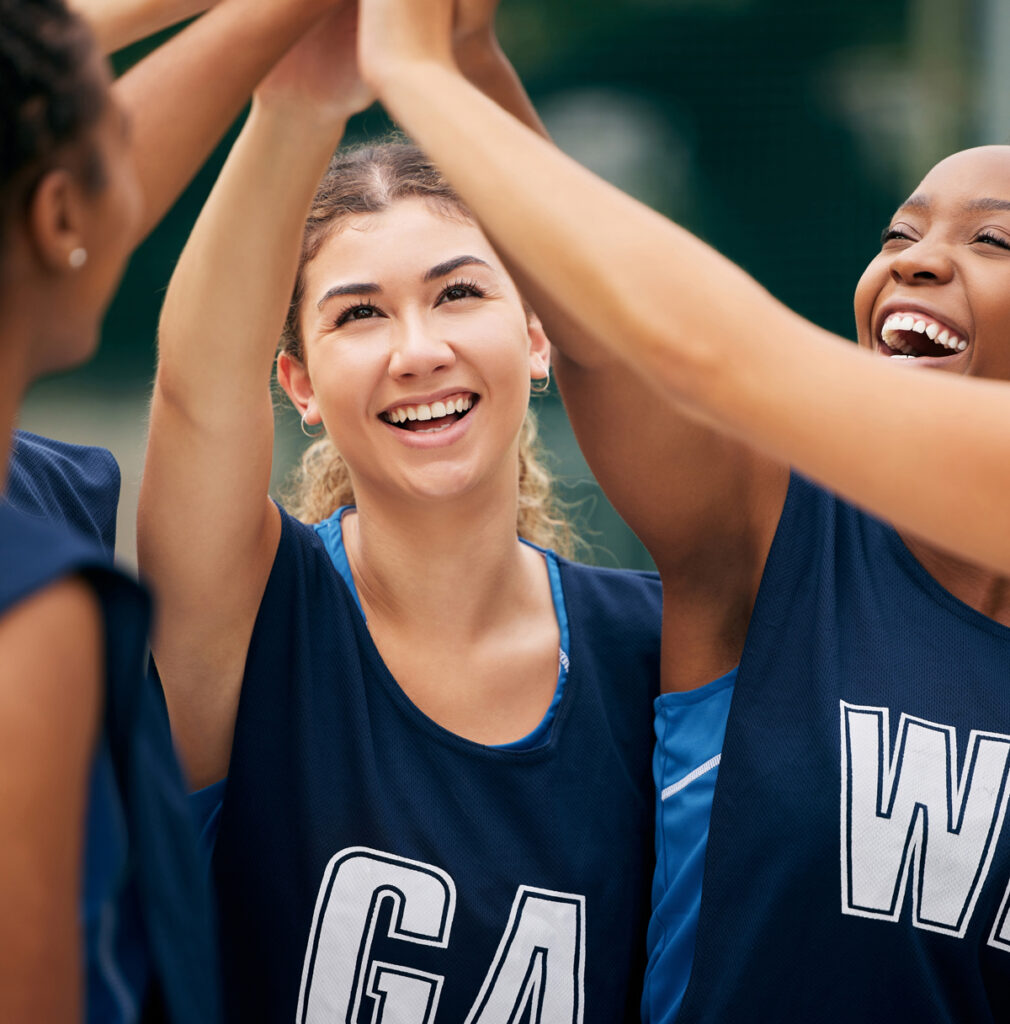 Team of girls with hands raised in the middle