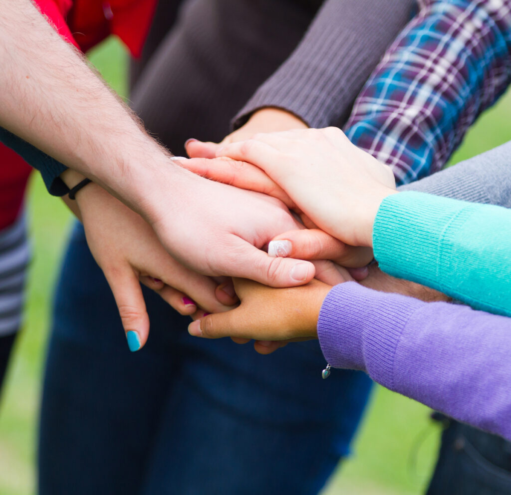 Team circle with hands in the middle