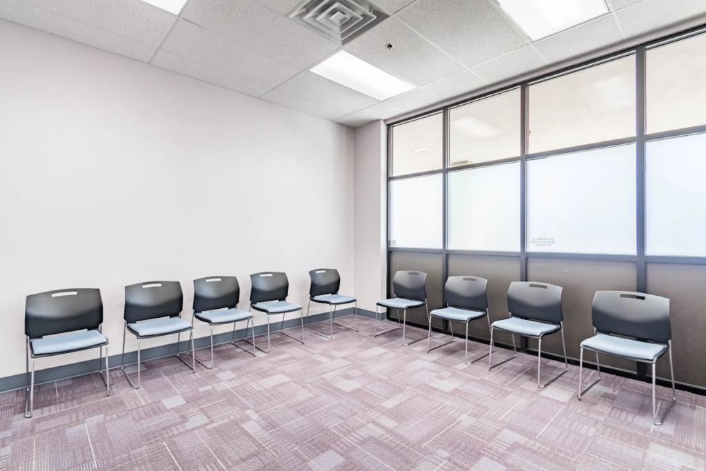 Open room with chairs lining the two walls in frame
